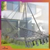 A hanging chair in a garden setting, with a house in the background. Voir les images du produit