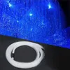 A coiled bundle of white fiber optic cable lies on a black surface in the foreground, with a background of blue fiber optic lights creating a starry sky effect. Produktbild-Vorschau