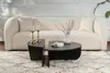A modern living room scene with a cream sofa and a black coffee table. Produktbild-Vorschau