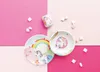 A unicorn-themed children's dinnerware set is arranged on a pink and light pink background, with marshmallows scattered around. Anteprima dell’immagine prodotto