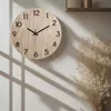 A wooden wall clock is shown hanging on a wall, with shadows cast by window blinds. Anteprima dell’immagine prodotto