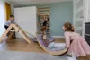 Children playing in a room with Montessori-style climbing and rocking equipment. Produktbild-Vorschau
