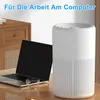 An air purifier is placed on a desk next to a laptop and a glass of water, with a wooden cabinet in the background. Produktbild-Vorschau