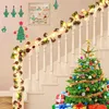 Christmas decorations on a staircase, including a garland with lights and pinecones, a Christmas tree, and wrapped gifts. Produktbild-Vorschau