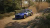 A blue rally car driving on a dirt road, kicking up dust. Podgląd zdjęcia produktu