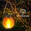A solar flame lantern hanging from a tree branch in the rain. Produktbild-Vorschau