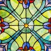 A close-up view of a stained glass window or suncatcher with intricate patterns and vibrant colors. Produktbild-Vorschau