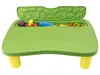 A green play table with yellow legs, filled with colorful toys and playdough accessories. The lid is open, revealing animal molds. Produktbild-Vorschau