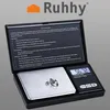 A digital scale with two diamonds on its weighing platform, placed inside its open case which displays instructions. Produktbild-Vorschau