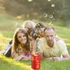 A family is lying on the grass, playing with a bubble machine. Produktbild-Vorschau
