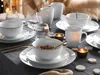 A table setting with white porcelain dishes, gold cutlery, and candles, suggesting a meal or celebration. Náhľad obrázku produktu