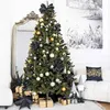 A decorated Christmas tree in a living room setting with a mirror, sofa, and gifts. Voir les images du produit