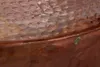 A close-up view of the hammered copper surface of a round table. Produktbild-Vorschau