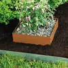 A square metal garden border with a plant inside, surrounded by soil and grass. Produktbild-Vorschau