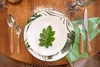 A table setting with plates, cutlery, and a leaf decoration. Náhľad obrázku produktu