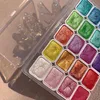 A close-up overhead view of a palette of 20 shimmering watercolor paints in a clear plastic case. Voir les images du produit