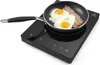 A black induction cooker with a frying pan containing eggs and bacon on top. Voir les images du produit