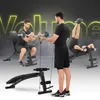 Three men are shown using a multi-functional weight bench in different exercise positions. The background has a smoky effect and the word "Volume" is displayed in large, neon-yellow letters. Náhľad obrázku produktu