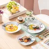 A table setting with plates of food, fruit, and a drink. Produktbild-Vorschau