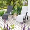 Two lounge chairs on a wooden deck with plants and trees in the background. Náhľad obrázku produktu