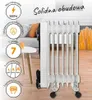 A white oil-filled radiator is shown in a living room setting with a couch and a small table. Voir les images du produit