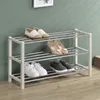 A three-tier shoe rack with shoes on each tier, against a greenish-gray wall. Produktbild-Vorschau