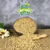 A bowl of birdseed with a wooden scoop and a decorative flower. Produktbild-Vorschau