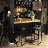 A modern bar area with two black bar stools and a wooden countertop. Voir les images du produit