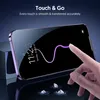 A hand is touching a smartphone screen, with a purple line tracing a path on the screen. The phone is purple and has a screen protector. There are small diamond-like objects on the reflective surface below the phone. Produktbild-Vorschau
