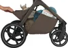 A close-up view of the storage basket of a stroller, showing a hand reaching into it. Náhled obrázku produktu