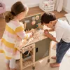Two children are playing with a wooden toy workbench and accessories. Náhled obrázku produktu