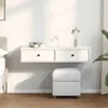 A white floating shelf with two drawers is mounted on a white wall above a white ottoman. The shelf has small decorative items on top, including jars and a vase with dried flowers. The scene is lit by natural light, casting shadows on the wall. Anteprima dell’immagine prodotto