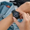 A person wearing a black Casio watch on their wrist, with a denim jacket in the background. Voir les images du produit