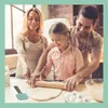 A family is baking together in a kitchen, with the daughter rolling out dough with a rolling pin. Anteprima dell’immagine prodotto