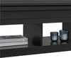 A close-up view of a black coffee table with two books stacked on the left shelf and two glass candle holders with candles on the right shelf. Produktbild-Vorschau