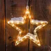 A star-shaped light decoration with snow on it, hanging against a wooden background. Produktbild-Vorschau
