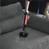A person is using a handheld vacuum cleaner to clean a sofa. Produktbild-Vorschau