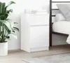 A white nightstand next to a bed, with a plant on the left. Náhled obrázku produktu