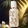 A perfume bottle with snake embellishments, surrounded by tropical leaves and a flower. Anteprima dell’immagine prodotto