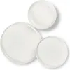 Three white ceramic plates of varying sizes are arranged on a white background. Voir les images du produit