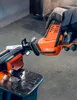 A person wearing gloves is using a reciprocating saw to cut a metal bar clamped in a vise. Produktbild-Vorschau