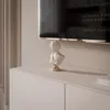 A white bust sculpture with a gold base sits on a light gray cabinet in front of a television screen. Voir les images du produit