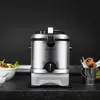A stainless steel deep fryer is shown on a dark countertop with a bowl of food and a small metal bucket of fried food next to it. Náhľad obrázku produktu
