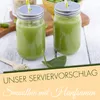 Two glasses of green smoothie with straws, a wooden spoon with seeds, and spinach leaves on a wooden table. Produktbild-Vorschau