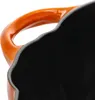 A close-up view of the interior and handle of an orange Staub pumpkin cast iron pot. Produktbild-Vorschau