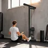 A man is exercising with a lat pulldown machine in a gym. Produktbild-Vorschau