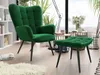 A green armchair and ottoman set in a well-lit room with plants and a large window overlooking a landscape. Náhľad obrázku produktu