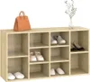 A wooden shoe rack with various shoes and a handbag on top, with a vase of greenery in the background. Podgląd zdjęcia produktu