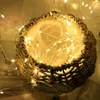 A woven basket filled with fairy lights, creating a warm and cozy atmosphere. Produktbild-Vorschau