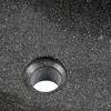 A close-up view of a dark gray speckled stone sink with a circular drain hole. Produktbild-Vorschau
